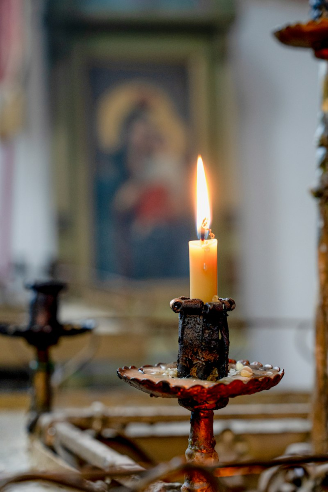 Свічка горить перед іконою в храмі